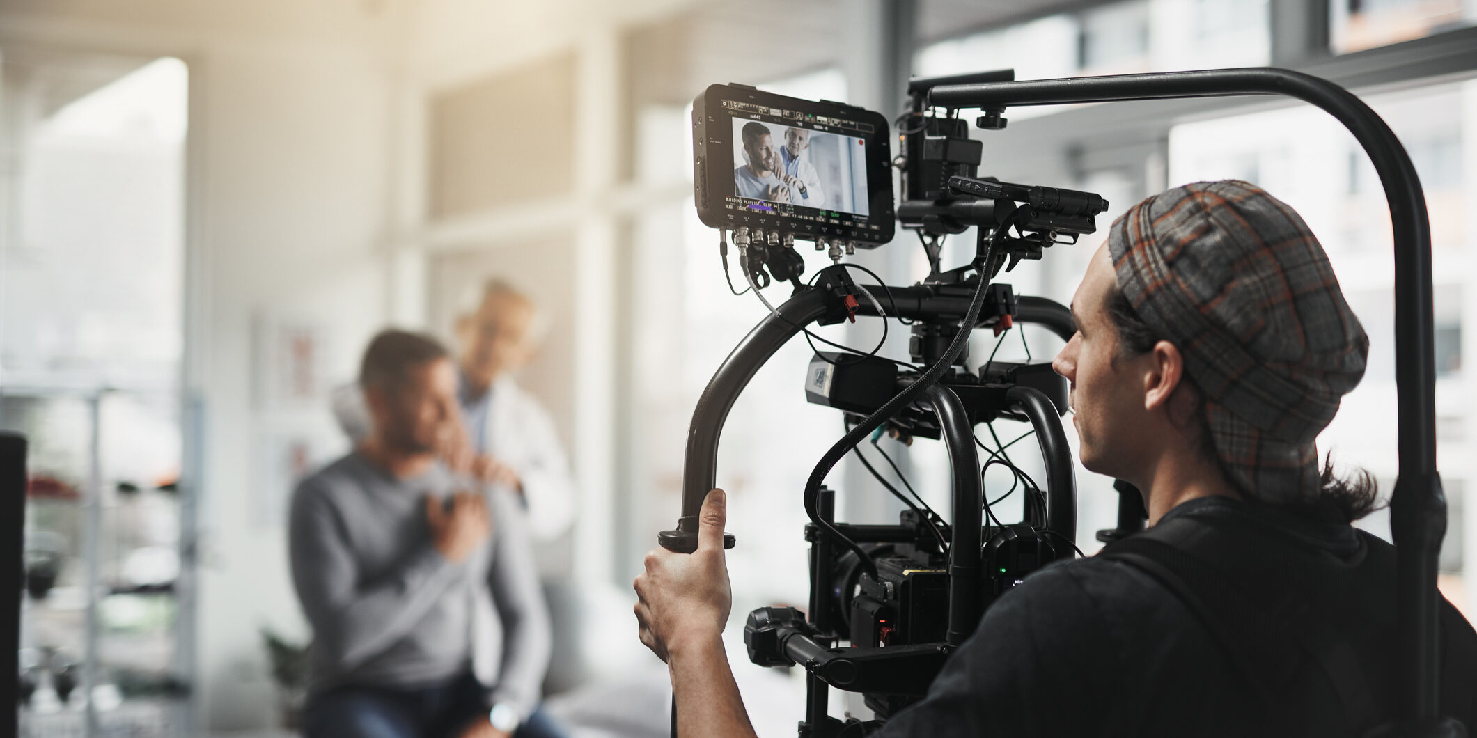 Behind the scenes shot of a camera operator shooting a scene with a state of the art camera inside of a studio during the day